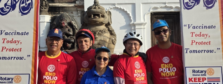 Five Rotary Club of Patan participants beneath the World Polio Day rally frame at Bhaktapur Durbar Square.