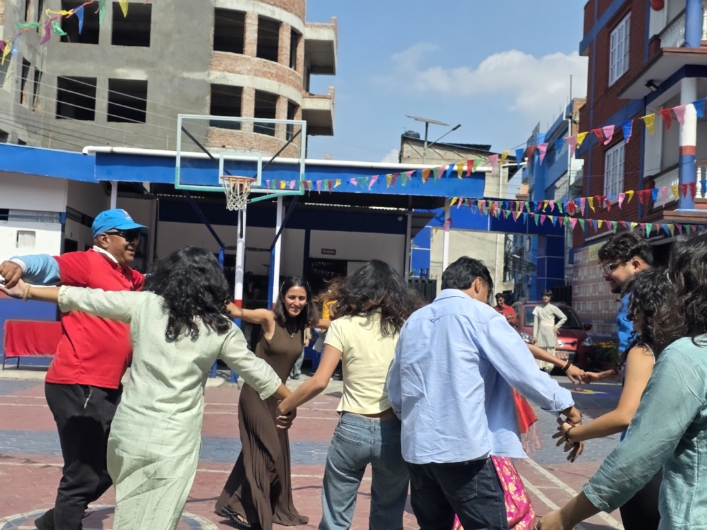 Rotarians and Rotaractors join hands in a circle dance in the courtyard of Bluebird Secondary School, Kumaripati.