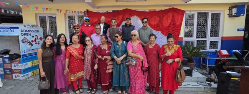 Rotarians, Rotaractors and guests gather in front of the decorated red-and-white stage at the Good Morning Tea Party, Bluebird Secondary School, 17 October 2026.